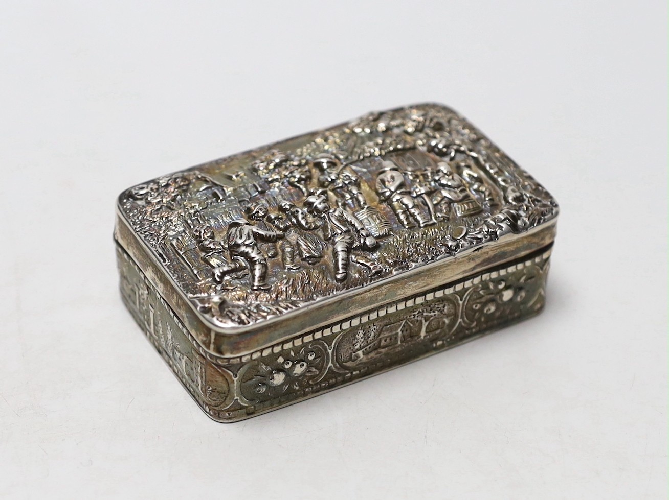 An early 20th century Hanau silver rectangular box, embossed with revellers, import marks for Sheffield, 1900, 87mm.